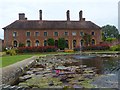 Lily pond and Strode House, Barrington Court Estate in TA19 0NQ