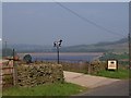 Entrance to Pott Hall farm and Leighton Reservoir mid ground in HG4 4LT