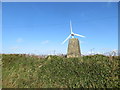 The hedge topping Lane End Field Triangulation Pillar sprouting a Wind Turbine in PL15 8PF