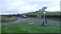 Signpost in a grass triangle in NP15 1DN