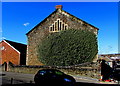 Overgrown south side of Grade II listed Calvaria Baptist Chapel, Llanelli in SA15 1JA
