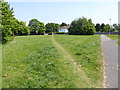 Grassy area with worn path to the main road in BN16 3TQ