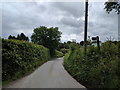 Lane to Tedburn St Mary, with Public Footpath sign on the right in EX6 6EB