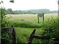 Footpath emerges from trees and changes direction in field in RH15 0BG