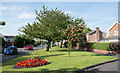 Grassed strip with flower bed and trees, in Ouston (County Durham)