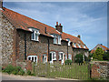 Line of cottages by road to Baconsthorpe Castle in Baconsthorpe