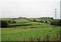 View from a Plymouth-Exeter train - fields and pylons near Bow Grange in TQ12 5UF