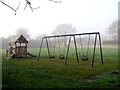 Swings in children's playground in NR10 3LQ