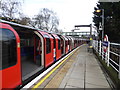 A Central line train at Roding Valley station in IG9 6EU