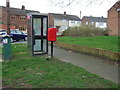 Elizabeth II postbox and telephone box on Woodlands Road in CV12 0AG