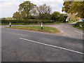 Road junction and grass triangle in MK18 2AL
