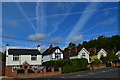 Aircraft trails above houses in Chertsey Road in GU20 6HS