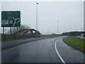 A56 Chester Road crossing the M56, with railway arch bridge beyond in WA7 3DL