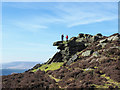 Walkers on rocks of White Tor in Derwent