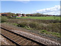 View from a Chester-Holyhead train - Housing around a playing field in LL18 4HT