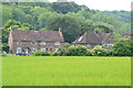 Houses at West Marden seen across crop field in PO18 9ET