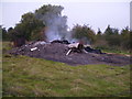 Smouldering bonfire on rubbish tip in MK44 3DH