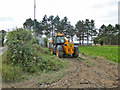 JCB behind hedge, Links Road in NR11 8DG