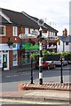 Shops on The Square behind an old signpost in NG12 5JN
