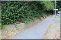 Wall and pavement beside Oakley Road approaching subway tunnel in NN17 1XA