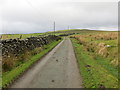 Minor road between stone wall and open ground near Parc-newydd in Cerrigydrudion Community