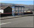 Blue bus shelter on the west side of Cardiff Road, Merthyr Vale in CF48 4QN