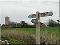 Footpath sign and church at Cawston in NR10 4AH