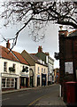 Looking NE past shops on High Street in NR25 6HR