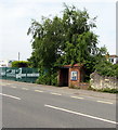 Brick bus shelter under a tree in Shurdington in GL51 4UQ
