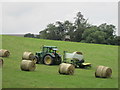 Wrapping bales of hay in field with tractor in TD7 4PE