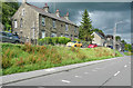 Houses and road above a grass bank, Thurlstone in S36 9RL