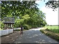 Cyclist pausing by the lych gate at Great Totham in Great Totham