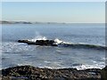 Waves breaking on a rock off Newton Point in CF36 5NF