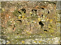 Pockmarked benchmark on the inn in BS39 5QQ