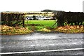 View through field gateway towards Station Road houses in CA11 0QU