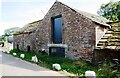 Farm buildings at The Luham on SE side of rural road in CA11 8TA