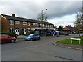 Shops and houses on Coombes Lane in B31 4TD