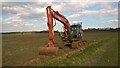 Highway maintenance Hitachi excavator on Helpston Road, Glinton in PE6 7LA