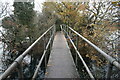 Footbridge carrying path between flooded gravel pits in TW17 0JH