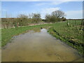 Flooded field entrance by Burton Brook in Burton and Dalby