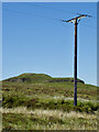Electricity transmission pole with the more interesting Cnoc nan Speireag behind in IV47 8SE