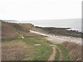 Coastal path approaching a footbridge over a stream at the head of Porth Helaeth in LL72 8LF