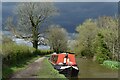 Red narrowboat under a stormy sky in SK10 5SJ