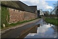 Farm buildings  reflected in puddle at Turners Puddle in DT2 7JB