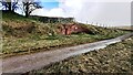 Remains of Sandy Bank signal box viewed across track bed of dismantled railway in CA17 4NX