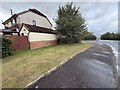 Grass patch by side of road in housing estate in EH33 2NE