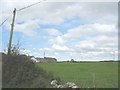 Farm buildings and bungalow at Erddreiniog viewed across pasture land in LL77 7UH